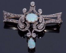 Opal and diamond set brooch centring a cabochon opal within an openwork scroll design set with