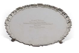 Elizabeth II shaped circular salver with 'Chippendale' edge supported on four paw feet, presentation
