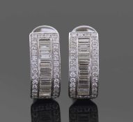 A pair of 18ct white gold and diamond curved earrings. A design featuring a central band of pave set