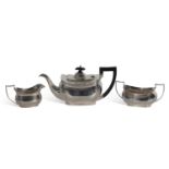 Three-piece tea set of slightly compressed oval form with reeded rims comprising teapot, two handled