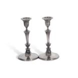 A pair of Edward Vll silver candle sticks, each with a ring turned tapered stem to a spreading