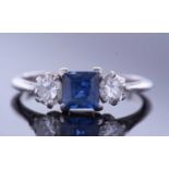 Sapphire and diamond three stone ring, centring a square cut sapphire flanked by two brilliant cut