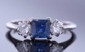 Sapphire and diamond three stone ring, centring a square cut sapphire flanked by two brilliant cut