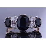 Sapphire and diamond ring featuring three oval cut graduated sapphires, highlighted between with