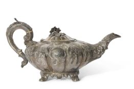 Large Victorian Irish silver teapot of melon form heavily embossed and chased with floral and
