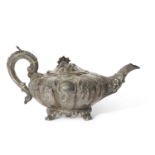 Large Victorian Irish silver teapot of melon form heavily embossed and chased with floral and