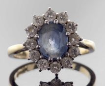 18ct gold sapphire and diamond cluster ring, the oval faceted pale sapphire set within a small
