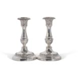 A pair of George IV candlesticks with baluster stem, and detachable nozzles. The loaded bases with