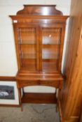 BRADLEY YEW WOOD VENEERED SMALL DISPLAY CABINET WITH TWO GLAZED DOORS OVER A BASE WITH TWO DRAWERS