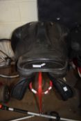 TWO LEATHER SADDLES AND A RED METAL SADDLE STAND