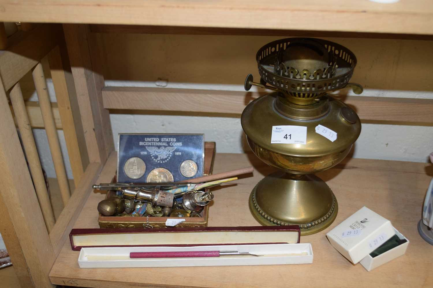 MIXED LOT BRASS OIL LAMP VARIOUS SMALL ORNAMENTS BOTTLE STOPPERS PENS AND CASED COINS SWAROVSKI