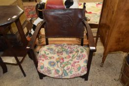 EARLY 20TH CENTURY OAK AND LEATHER BACKED LOW ARMCHAIR WITH GEORGE AND THE DRAGON DECORATION