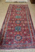 MIDDLE EASTERN WOOL RUNNER CARPET DECORATED WITH GEOMETRIC DETAIL ON A PRINCIPALLY RED BACKGROUND,