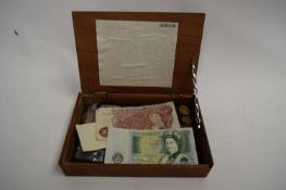 SMALL WOODEN BOX CONTAINING VARIOUS PRE-DECIMAL BRITISH AND FOREIGN COINAGE AND A 10/- AND £1 BANK