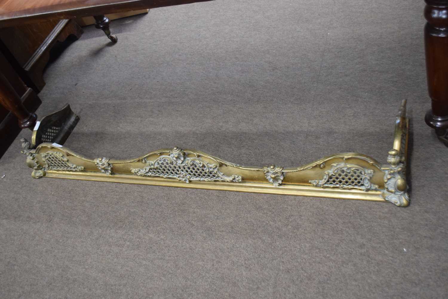 Cast brass fire fender of serpentine form with pierced and floral decoration, 137cm wide