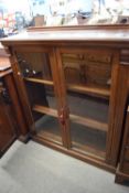 Victorian mahogany bookcase cabinet with two glazed doors opening to a shelved interior, set on a