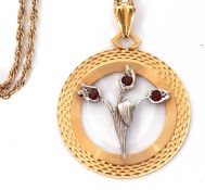 9ct bi-colour gold open work pendant centring a floral spray set with three small garnets on a 9K