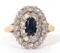 Sapphire and diamond cluster ring centring an oval sapphire raised above two tiers of small single
