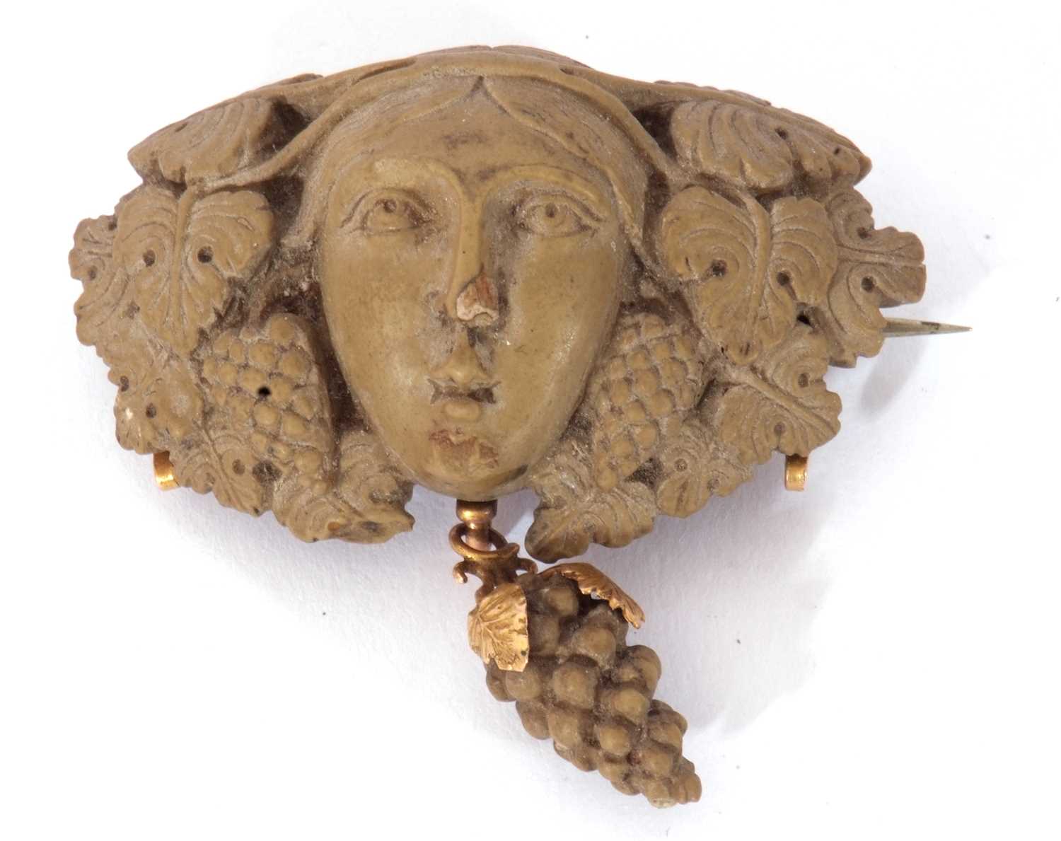 Antique lava brooch in relief a head between vine leaves with a bunch of grapes dropper below, 5cm