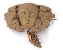 Antique lava brooch in relief a head between vine leaves with a bunch of grapes dropper below, 5cm