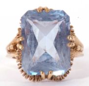 9ct gold light blue stone dress ring, the rectangular faceted stone cardinal set and raised in a