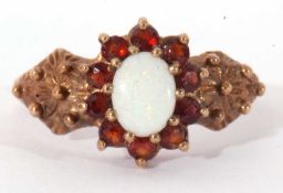 9ct gold opal and garnet cluster ring, the oval cabochon opal multi-claw set and raised above a