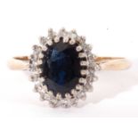 9ct gold sapphire and diamond cluster ring, the oval faceted dark sapphire multi-claw set within a