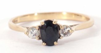 9ct gold sapphire and diamond three stone ring centring a small oval cut sapphire flanked by two