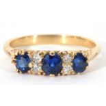 Sapphire and diamond ring featuring three oval faceted sapphires, highlighted between with four