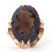9ct gold and quartz dress ring, the oval faceted quartz 20 x 8mm, cardinal set in a basket mount,