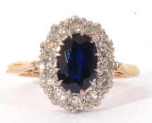 18ct gold sapphire and diamond cluster ring, the oval faceted sapphire 8.8 x 6.2mm, raised above a