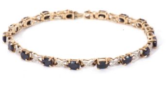 Modern sapphire and diamond bracelet, a design featuring 17 oval shaped dark sapphires joined by X