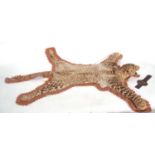 A Juvenile Leopard (Panthera pardus) skin rug on a brown felt mount by the Theobald Bros of