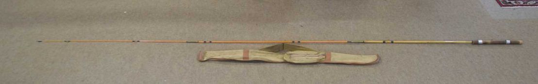 A 20th-century 3-part bamboo fly fishing rod with cork handle grip and 6x line grommets. Overall