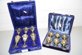 TWO CASES OF MINIATURE BRASS AND SILVER PLATED GOBLETS