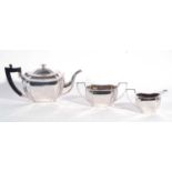 Three piece white metal tea set comprising teapot, sucrier and milk jug of plain form with