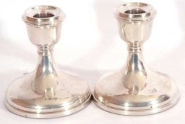 Pair of hallmarked silver small candle sticks of squat form with weighted bases, hallmarked
