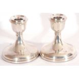 Pair of hallmarked silver small candle sticks of squat form with weighted bases, hallmarked