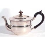 George V silver teapot of slight compressed circular form with hinge lid summounted by an urn