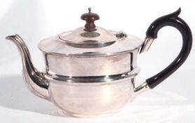 George V silver teapot of slight compressed circular form with hinge lid summounted by an urn