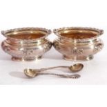 Cased George V pair of salts and spoons of oval form, the rims gadrooned and ribbon decorated with
