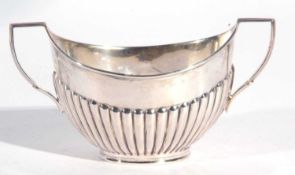 George V silver twin handled sugar bowl of oval form the body with a half fluted design to a