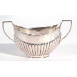 George V silver twin handled sugar bowl of oval form the body with a half fluted design to a