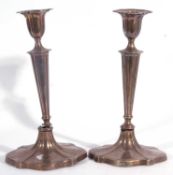 A pair of Edward VII silver candlesticks with fluted tapering V shaped stems to a spreading shaped