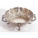 Edward VII silver bonbon dish of circular scalloped form raised on four dragons feet, decorated with