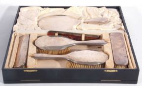 A cased dressing table set, comprising hand mirror, two hairbrushes, two clothes brushes and a