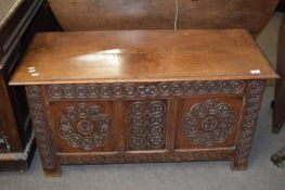 18th Century oak coffer, hinged top over a base with a three panelled front with carved floral