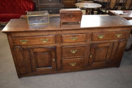Georgian oak dresser base fitted with two short and three long drawers and two panelled doors, 189