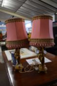 Pair of gilt finish plaster based figural table lamps with pink shades, approx 70 high