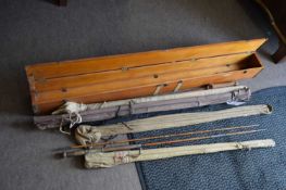 Wooden case containing a collection of various vintage fishing rods